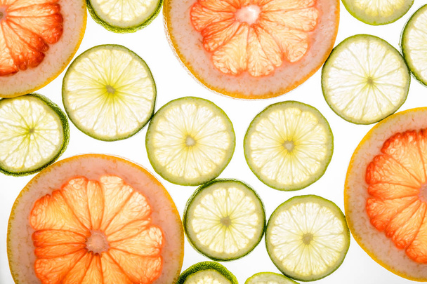 Bright lime and grapefruit slices on white - Фото, изображение