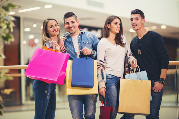 Groupe de jeunes amis faisant du shopping dans le centre commercial ensemble
 - Photo, image
