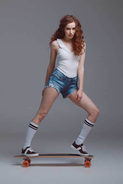 Stylish young woman with skateboard  - Fotografie, Obrázek