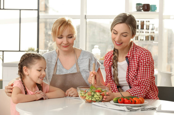 Young woman with mother and daughter in kitchen - Фото, зображення