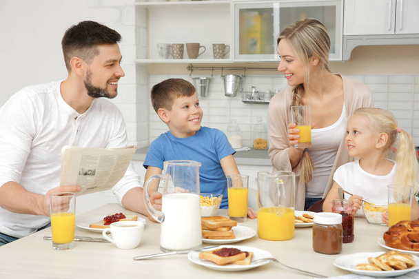 Happy family having breakfast on kitchen - Fotó, kép