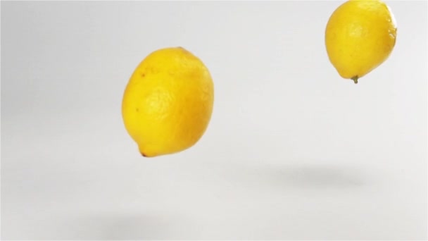 ein paar Zitronen fallen auf weiße nasse Oberfläche - Filmmaterial, Video