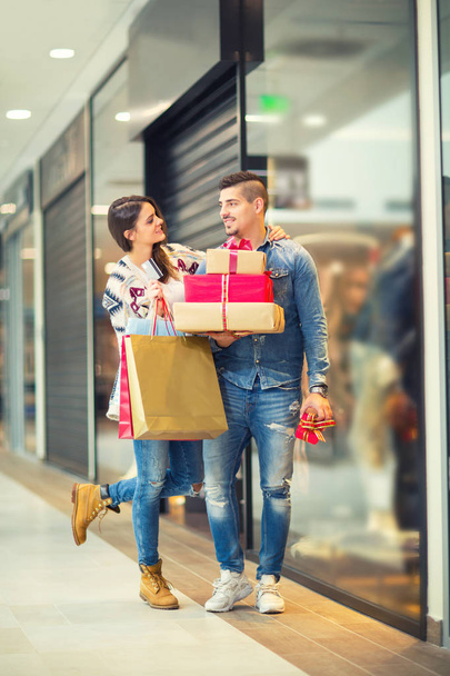 Couple with Christmas presents, gifts and shopping bags in a mall - Photo, Image
