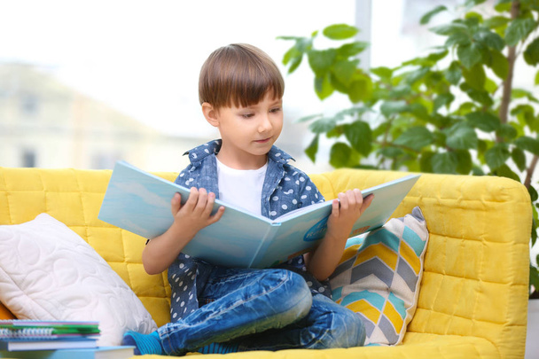 Cute little boy reading book at home - Fotografie, Obrázek