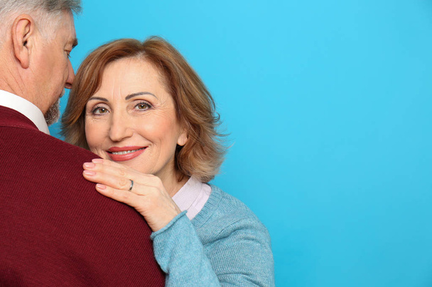 Happy senior woman embracing her husband on color background - Fotografie, Obrázek