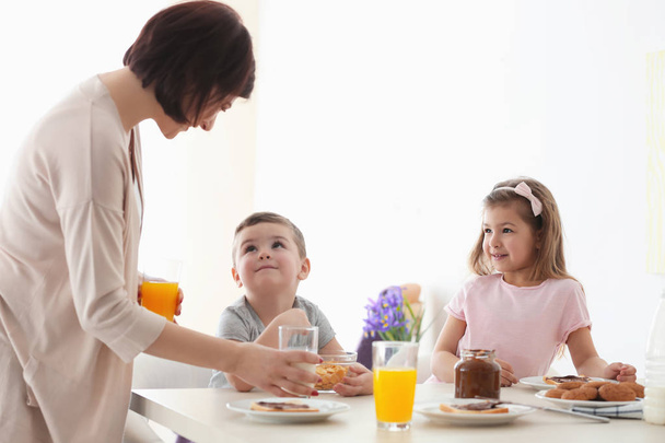 Mother and children having breakfast at home - Fotó, kép