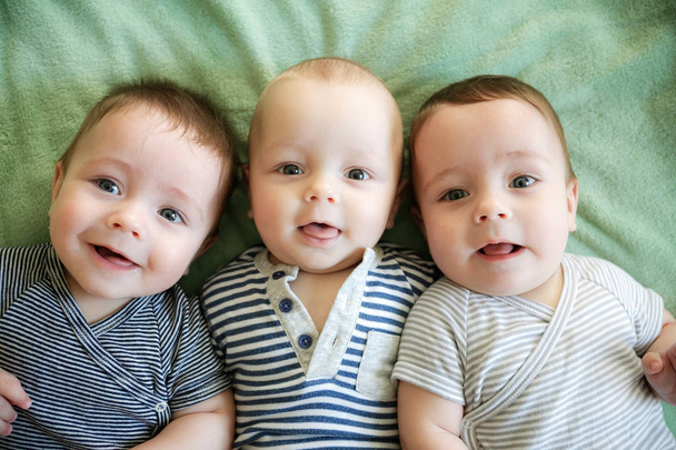 Retrato de trigêmeos recém-nascidos estão deitados na cama
 - Foto, Imagem