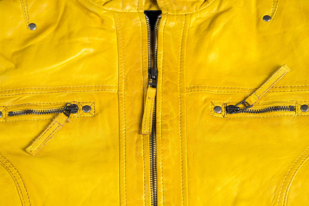 Yellow textured leather jacket zippers. Leather jacket macro details. Jacket zippers and pockets - Zdjęcie, obraz