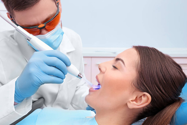 Dentist examining patient's teeth in clinic - Fotoğraf, Görsel