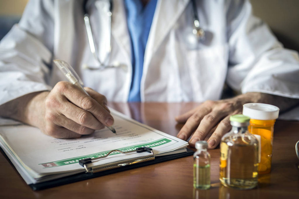 Médico escribiendo notas del paciente en un examen médico o prescripción médica - Foto, Imagen