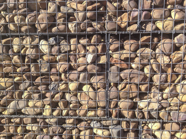 Стена защищена речными камешками в железной сетке
 - Фото, изображение