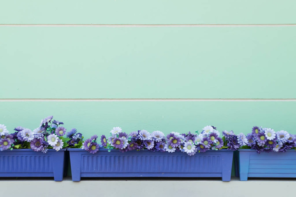 Blue rectangular flowerpot against turquoise wall - Photo, Image