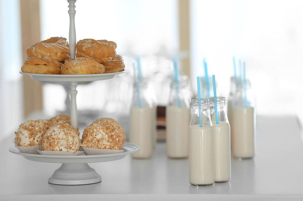 Table with bottles of milk and dessert stand - 写真・画像