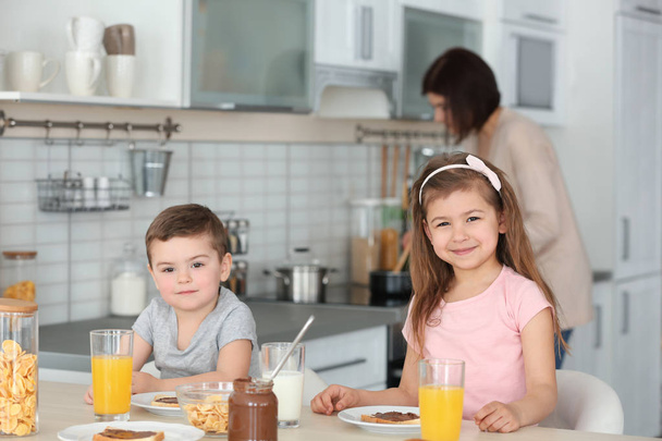 Cute little children having breakfast at home - Foto, immagini
