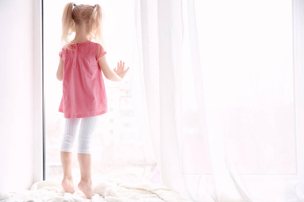 little girl standing on windowsill - Valokuva, kuva