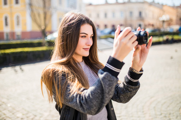 Outdoor smiling lifestyle portrait of pretty young woman having fun in the city in Europe with camera travel photo of photographer making pictures - Valokuva, kuva