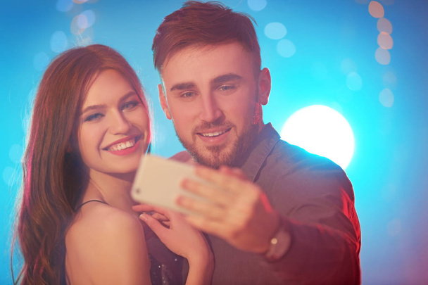 Young couple taking selfie at party in night club - Foto, Imagem