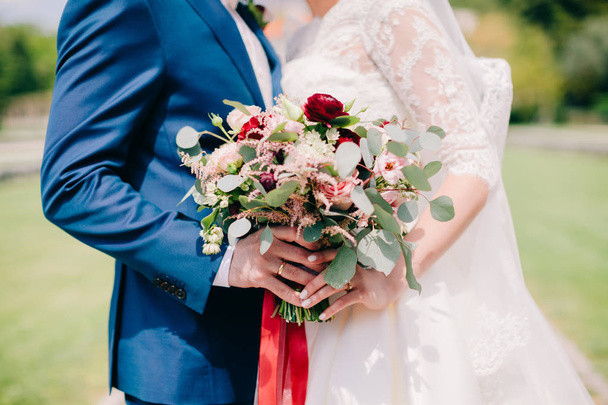 nevěsta a ženich drží svatební kytice - Fotografie, Obrázek