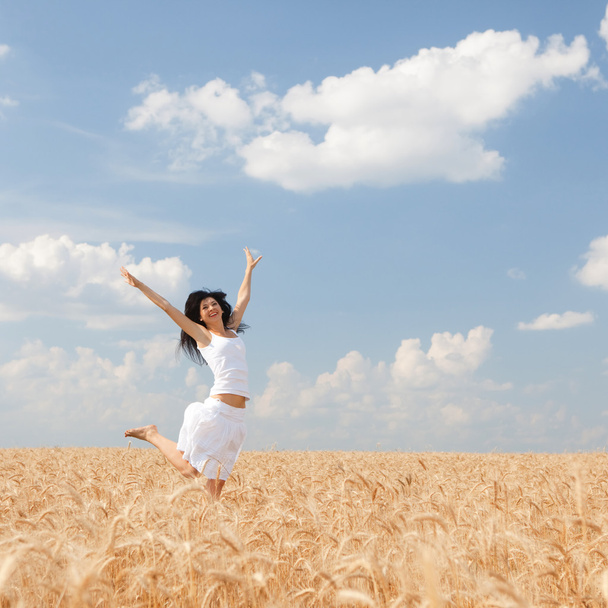 Happy woman jumping in golden wheat - Zdjęcie, obraz
