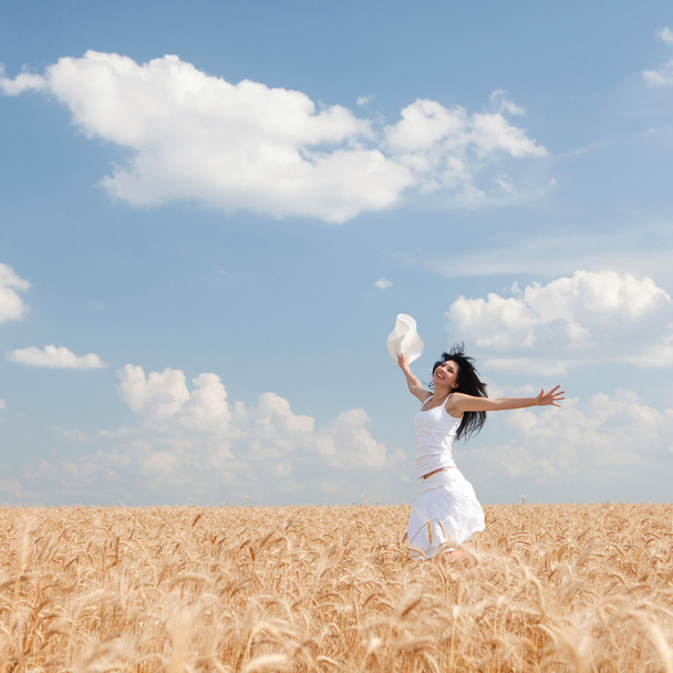 Mujer feliz saltando en trigo dorado
 - Foto, imagen