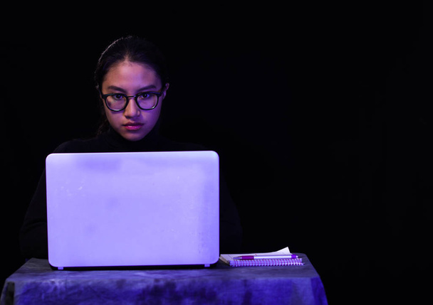 Portrait of hacker with laptop on dark background - Foto, imagen