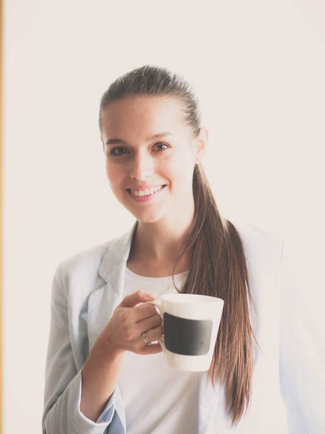 Attractive woman sitting at desk in office having takeaway coffee - Foto, imagen
