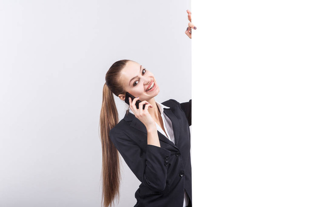 Jeune femme d'affaires avec téléphone à côté d'un tableau blanc
  - Photo, image
