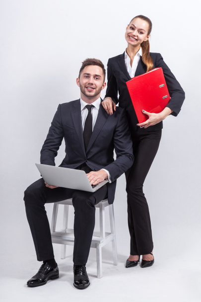 Jovens empresários com um laptop e pastas de escritório
 - Foto, Imagem