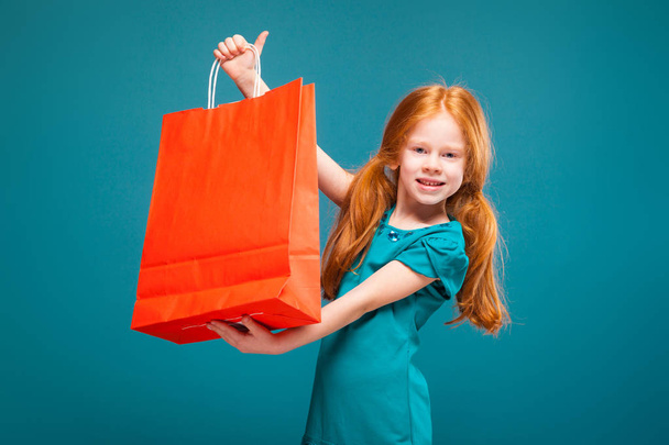 Χαριτωμένο κοκκινομάλλα κοπέλα με τσάντα για ψώνια - Φωτογραφία, εικόνα