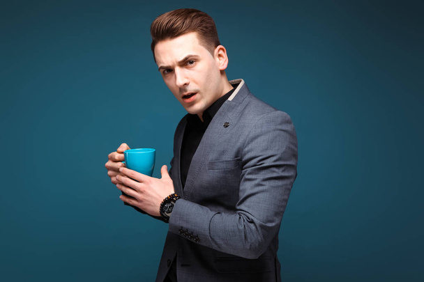 Young handsome businessman with blue cup - Фото, зображення