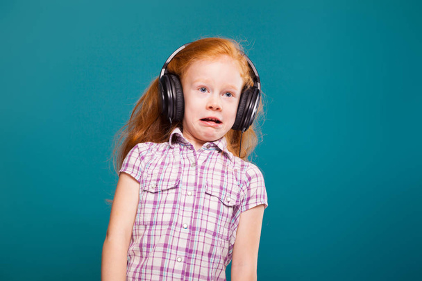 Χαριτωμένο κοκκινομάλλα κοπέλα στα ακουστικά - Φωτογραφία, εικόνα