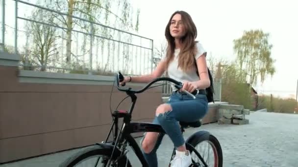 Beautiful woman rides a bicycle near a tall building 4k - Footage, Video