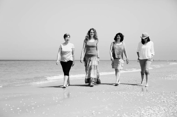 海辺を歩く熟女 - 写真・画像