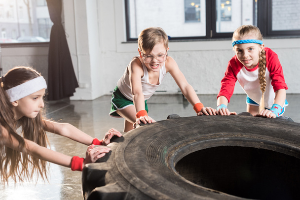 kids training with tire at fitness studio - Фото, изображение