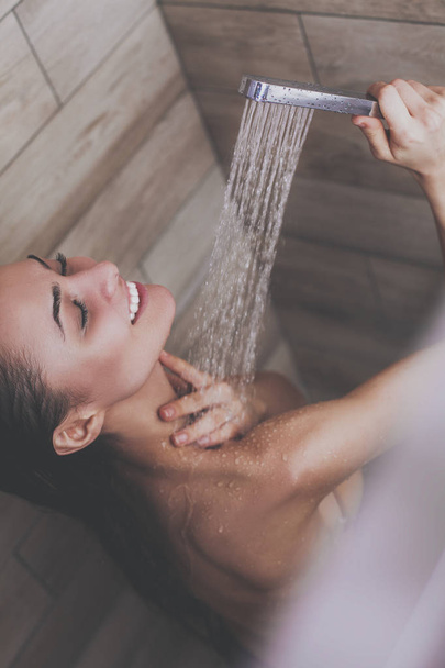 Young beautyful woman under shower in bathroom - Valokuva, kuva
