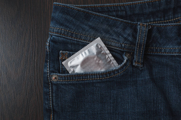Preservativos embalados em jeans. Conceito de sexo seguro. Medicina de saúde, contracepção e contracepção. Fechar pílulas contraceptivas orais. Proteção contra gravidez indesejada. Protecção contra a SIDA
 - Foto, Imagem