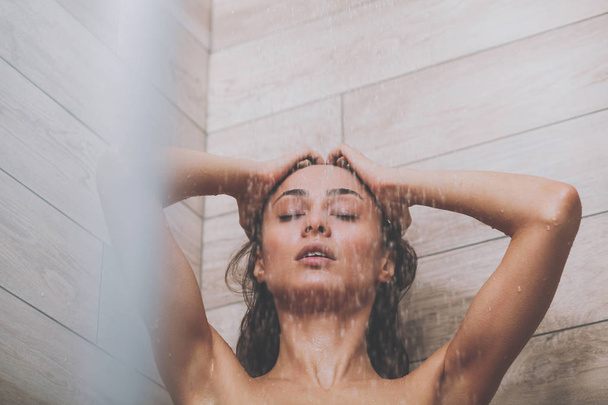 Young beautyful woman under shower in bathroom - Photo, Image