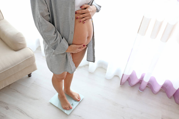 Pregnant woman on scales  - Foto, Imagem