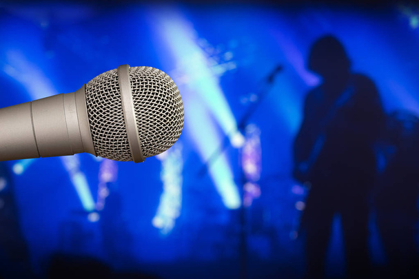 Microfono da palco con un chitarrista sullo sfondo sfocato posteriore
 - Foto, immagini