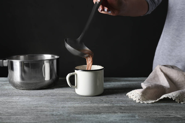 Pouring tasty cocoa into mug  - Valokuva, kuva