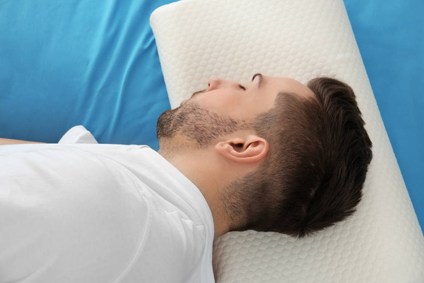 Fiatalember fekszik az ágyon   - Fotó, kép