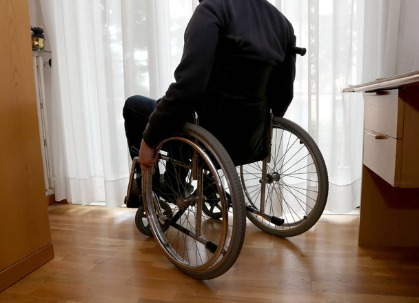 інвалід у своїй спальні зі столом
 - Фото, зображення