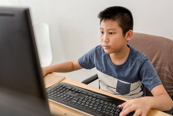 Asian boy playing computer game at home. - Photo, image