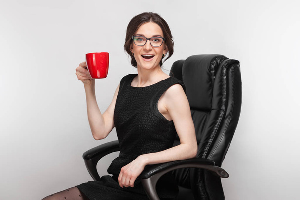 Vrouw in de fauteuil met koffie - Foto, afbeelding