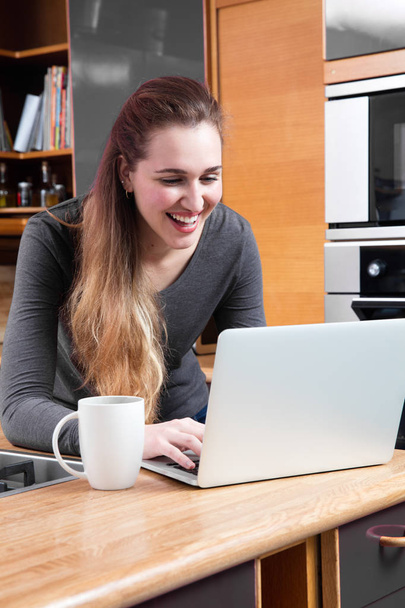 сміється молода жінка з комп'ютером для телекомунікацій або купівлі в Інтернеті
 - Фото, зображення