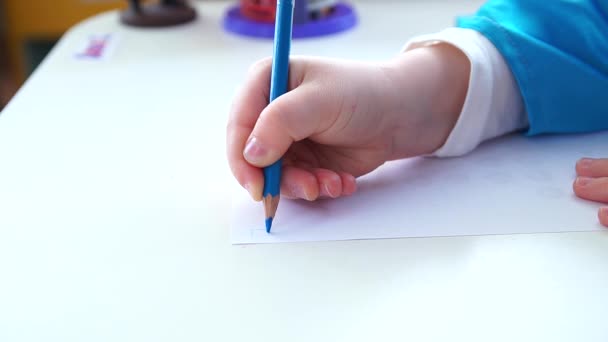 The child writes the letter on paper. - Video, Çekim