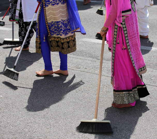 πολλές γυναίκες Σιχ ξυπόλυτος σαρώσεως του δρόμου ενώ - Φωτογραφία, εικόνα