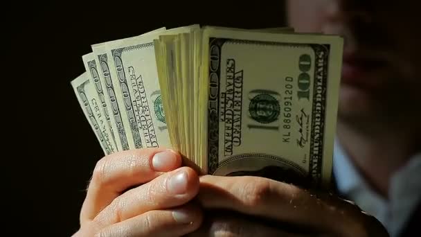 Mladý podnikatel detail se počítá své peníze ve tmě - Záběry, video