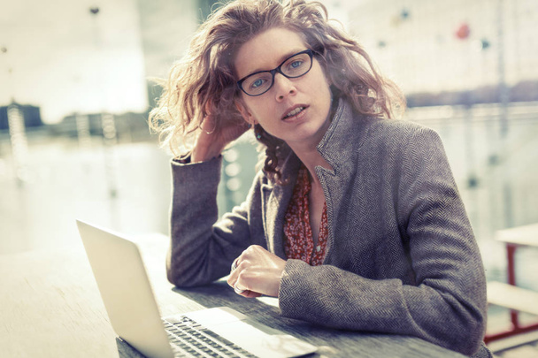 Femme d'affaires assis en plein air, travaillant sur son ordinateur
 - Photo, image