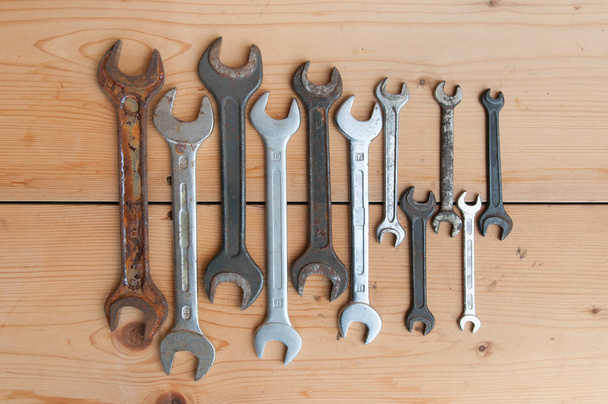 Vecchie chiavi e pinze su fondo di legno. Una serie di attrezzi. Vista dall'alto
 - Foto, immagini